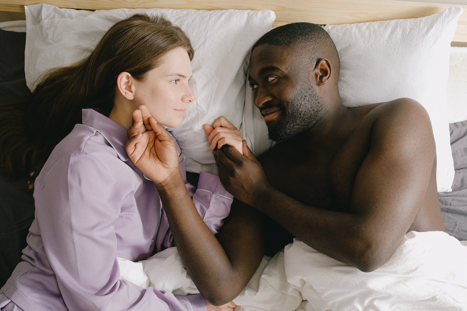 Couple Lying on Bed while Looking Face to Face