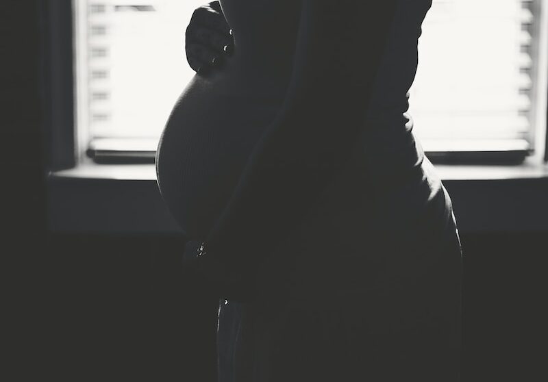 pregnant woman standing inside room during daytime